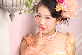 卒業袴 オレンジ色のドレスはピンクの背景で可愛らしく
