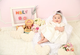 ベビー 真っ白なドレスにお花のヘアバンドを付けて、ハーフバースデーの記念に